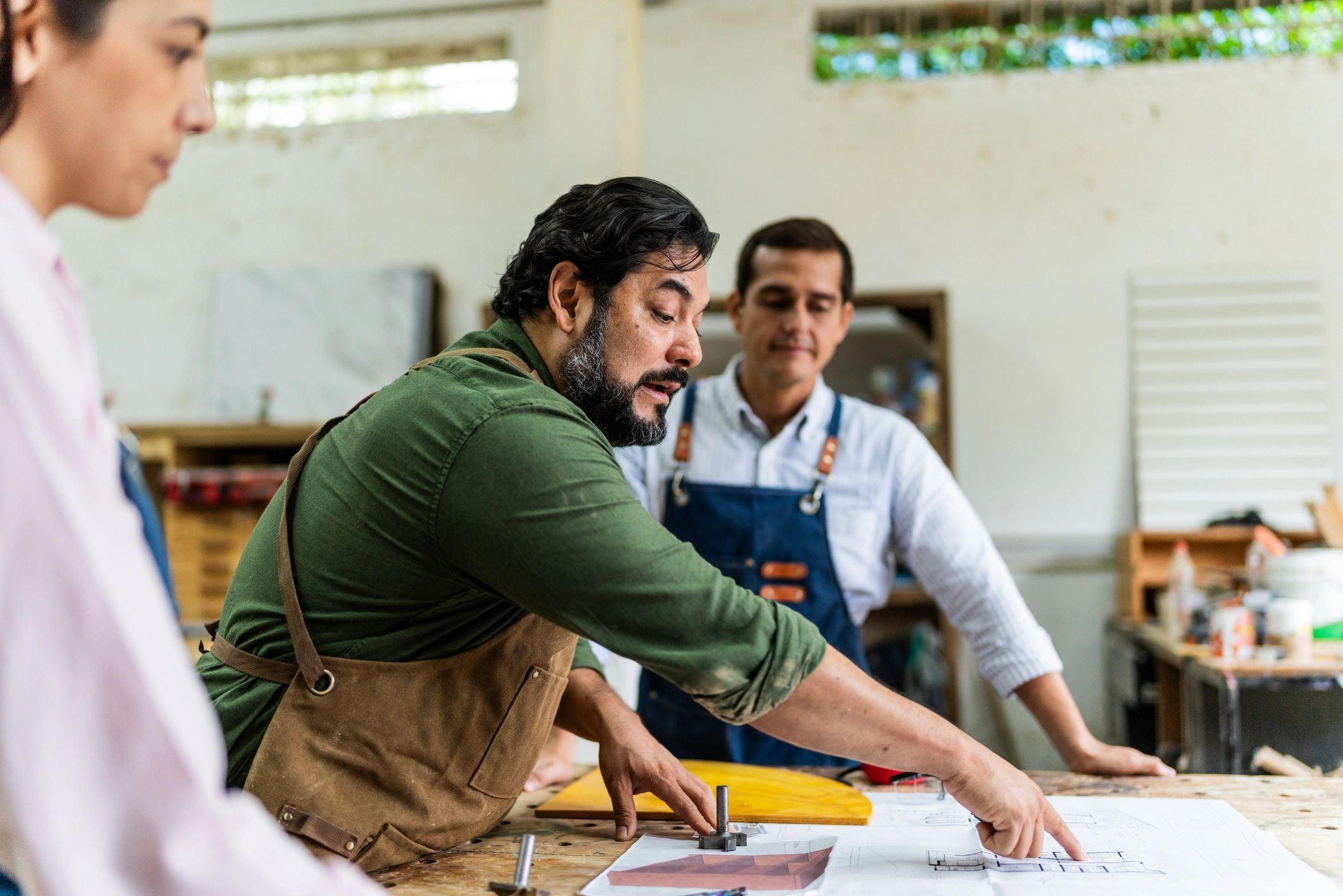 Craftsman speaking with coworkers in a workshop