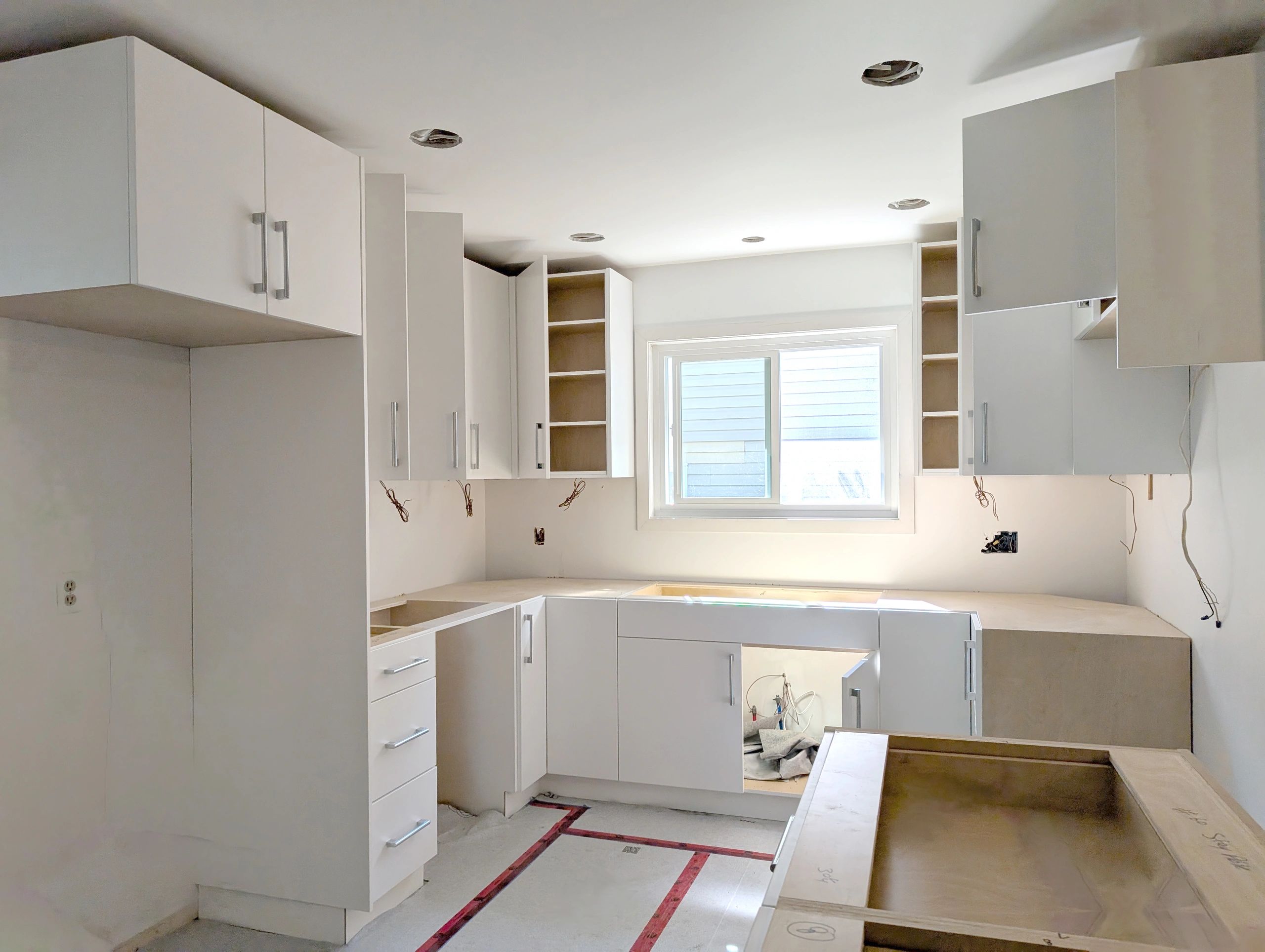 Newly installed white kitchen cabinets in renovation project